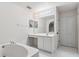 Bright bathroom features a soaking tub, vanity, large mirror and double door closet at 181 Zachary Wade St, Winter Garden, FL 34787