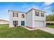 Charming two-story home featuring a manicured lawn, blue front door and attached two-car garage at 181 Zachary Wade St, Winter Garden, FL 34787