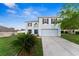 Traditional two-story home boasting manicured lawn, lush landscaping, and attached two-car garage at 181 Zachary Wade St, Winter Garden, FL 34787