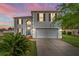 Charming two-story home with a well-maintained lawn and two car garage at sunset at 181 Zachary Wade St, Winter Garden, FL 34787