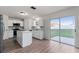 Open kitchen boasts white cabinets, island, stainless appliances, and sliding glass doors to the backyard at 181 Zachary Wade St, Winter Garden, FL 34787