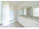 Spacious bathroom featuring a double vanity with white cabinets and a walk-in shower at 1811 Silverbell Loop, Haines City, FL 33844