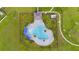 Birds eye view of the community pool featuring a unique design, blue umbrellas, and lounge chairs at 1811 Silverbell Loop, Haines City, FL 33844