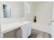 Bright bathroom featuring a tub, a well-lit vanity, and stylish gray wood-look flooring at 1832 Corner Meadow Cir, Orlando, FL 32820