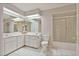 Bright bathroom featuring a double vanity, a toilet, white tile floors, and a bathtub with shower at 2011 Oakbend Dr, Eustis, FL 32726
