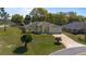 Well-kept home with lush lawn, mature trees, and spacious driveway offers desirable curb appeal at 2011 Oakbend Dr, Eustis, FL 32726
