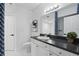 Clean bathroom featuring white cabinets, a vanity with black counter top, and a tiled shower and tub at 202 E South St # 5046, Orlando, FL 32801
