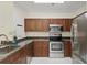 Well-equipped kitchen with stainless steel appliances, wood cabinets, and granite countertops at 202 E South St # 5046, Orlando, FL 32801
