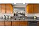 Kitchen pass-through to living room offers granite counters, stainless sink and appliances, and wood cabinets at 204 Quayside Cir # 501, Maitland, FL 32751