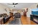 Spacious living room with hardwood floors, leather furniture, a ceiling fan and an electric fireplace at 204 Quayside Cir # 501, Maitland, FL 32751