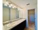 Bathroom vanity featuring double sinks, granite countertops, and modern lighting at 2144 Rookery Ln, Sanford, FL 32773