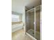 Bright bathroom featuring a walk-in shower and a soaking tub by the window at 2144 Rookery Ln, Sanford, FL 32773