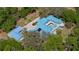 Aerial view of the home with a blue roof surrounded by lush greenery and brick driveway at 2240 W Dale Cir, Deland, FL 32720
