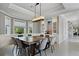 Elegant dining room with a long wooden table, designer lighting, and built-in display cabinets, inviting gatherings at 2240 W Dale Cir, Deland, FL 32720