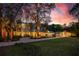 Stately home featuring a beautiful brick driveway, lush landscaping, and stunning sunset views at 2240 W Dale Cir, Deland, FL 32720