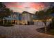 Stunning home at dusk featuring custom lighting and beautiful exterior finishes with a spacious driveway at 2240 W Dale Cir, Deland, FL 32720