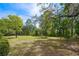 Large and beautiful green front yard with trees and bright blue sky at 2240 W Dale Cir, Deland, FL 32720