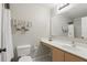 Well-lit bathroom featuring a large mirror, toilet, and clean white walls at 2662 Haulover Blvd, Deltona, FL 32738