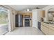 Open kitchen area with appliances, light wood cabinets, and sliding glass door that leads to back yard at 2662 Haulover Blvd, Deltona, FL 32738