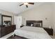 Comfortable main bedroom with tiled floor, ceiling fan, large dresser, and ensuite bathroom at 2662 Haulover Blvd, Deltona, FL 32738