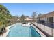 Beautiful backyard pool with sun loungers and an umbrella, surrounded by mature trees at 2662 Haulover Blvd, Deltona, FL 32738