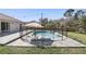 Backyard pool area featuring a safety fence, lounge chairs, and mature trees at 2662 Haulover Blvd, Deltona, FL 32738