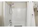 Clean white tiled shower with an adjustable shower head and convenient shelving at 2662 Haulover Blvd, Deltona, FL 32738