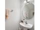 Clean powder room featuring a pedestal sink, round mirror, and towel bar at 2804 Polvadero Ln # 107, Orlando, FL 32835