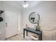 Bright foyer with a white door, console table, decorative mirror, and tile flooring at 2804 Polvadero Ln # 107, Orlando, FL 32835