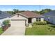 Inviting single-story home with a two-car garage, manicured lawn, and stylish stone accents at 2871 Parkfield Rd, St Cloud, FL 34772