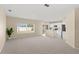 Bright living room featuring neutral paint, plush carpeting, and an open layout connecting to the kitchen at 2871 Parkfield Rd, St Cloud, FL 34772