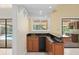 Wet bar with granite countertops, wood cabinets, and views of the pool at 2931 Sunbittern Ct, Windermere, FL 34786