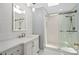 Modern bathroom featuring a glass shower, white vanity, and decorative mirror at 2931 Sunbittern Ct, Windermere, FL 34786