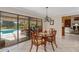 Inviting dining area with pool view, featuring a round table and decorative chandelier at 2931 Sunbittern Ct, Windermere, FL 34786