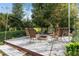Backyard fire pit area with a white wooden deck, seating, and a view of the trees in the neighborhood at 2931 Sunbittern Ct, Windermere, FL 34786