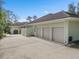 Side view of a home featuring a three-car garage, additional parking, and landscaping against a blue sky at 2931 Sunbittern Ct, Windermere, FL 34786