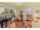 Inviting living room featuring wood floors, a grand piano, and an open layout to the dining area at 2931 Sunbittern Ct, Windermere, FL 34786