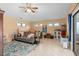 A comfy living room with tan walls, a large sofa, and a view of the outdoors through multiple windows at 2931 Sunbittern Ct, Windermere, FL 34786