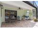 Covered outdoor seating area features a ceiling fan and comfortable furniture, with views of the screened in pool at 2931 Sunbittern Ct, Windermere, FL 34786