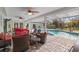 Screened in patio features wicker furniture with red cushions at 2931 Sunbittern Ct, Windermere, FL 34786