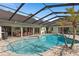 Inviting screened-in pool with hot tub, outdoor seating, and lush landscaping at 2931 Sunbittern Ct, Windermere, FL 34786