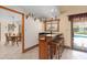 Stylish wet bar with seating, glass shelving, and convenient access to the outdoor pool area at 2931 Sunbittern Ct, Windermere, FL 34786