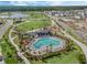 Aerial view of community pool, playground and manicured green spaces with palm trees at 2970 Scout St, St Cloud, FL 34771