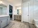 Bright bathroom featuring wood tile flooring, double vanity, and modern lighting at 2970 Scout St, St Cloud, FL 34771