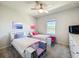 Bedroom features twin beds, carpet, ceiling fan, bright window and side tables between the beds at 2970 Scout St, St Cloud, FL 34771