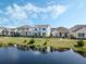 Beautiful exterior view of houses near a serene pond under a partly cloudy sky at 2970 Scout St, St Cloud, FL 34771