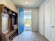 Charming foyer showcasing a blue door, built-in bench, and wood-look tile flooring at 2970 Scout St, St Cloud, FL 34771