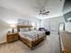 Spacious main bedroom with a ceiling fan, wood furniture, sitting area and carpet flooring at 2970 Scout St, St Cloud, FL 34771
