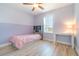 Charming bedroom with lavender accents, wood-look floors, and ample natural light at 3127 Via Otero Dr, Kissimmee, FL 34744