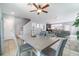 Open-concept dining area with a modern table set, ceiling fan, and easy access to the kitchen and living spaces at 3127 Via Otero Dr, Kissimmee, FL 34744